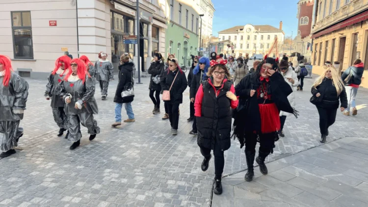 Tradicionalni pokop pusta z udeleženci v maskah in kostumih na ulicah Celja.